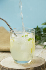 Canvas Print - Vertical shot of water being poured into a cup of fresh cold lemonade