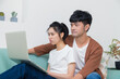 © JingLing - Asian woman and man working on laptop at home and thinking.