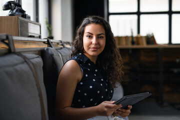 Wall Mural - Portrait of young businesswoman indoors in office, looking at camera.