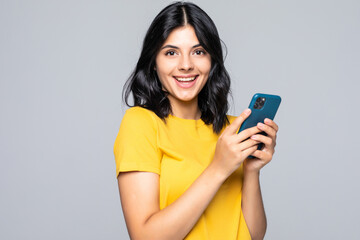 typing message to friend. attractive young woman holding smart phone and looking at it with smile wh