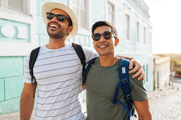 Wall Mural - Two happy male tourists walking with backpacks. Travel and love concept in Latin America