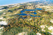 © AmazingAerialAgency - Aerial view of dunes, lakes and the North Sea coast on a misty day, Meijendel, Zuid-Holland, Netherlands