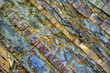 Layered structure of colored stone rock close up