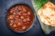 Traditional slow cooked American Tex-Mex meatballs chili with mincemeat and beans in a spicy sauce offered with pita bread as top view in a design cast-iron roasting dish with copy space