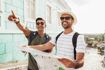 Wall Mural - Two happy male tourists using map. Travel and love concept in Latin America