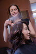 © Andersen Ross Photography/Stocksy - Styalist applying product to customers hair at salon
