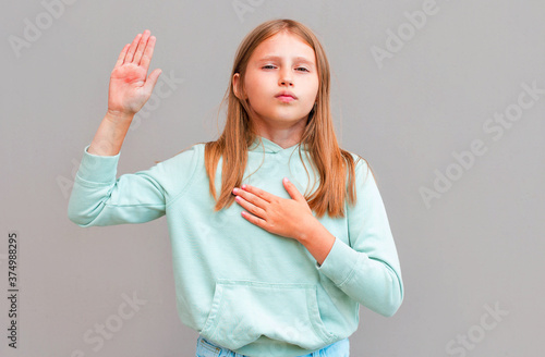 Photographie Optimistic, honest and cute girl give oath, swear tell truth, put hand on heart