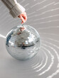 © Pixel Stories/Stocksy - Hand spinning disco ball