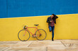 © Guille Faingold/Stocksy - Young woman standing beside his bicycle using her smartphone