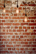 © Gillian Vann/Stocksy - brick wall with 3 hanging pendant lights