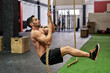 © Guille Faingold/Stocksy - Man climbing a rope in a gym