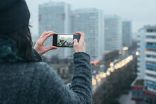 Woman Taking Photo With Smartphone On Berlin Rooftop On Rainy Winter Day