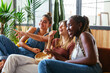© BONNINSTUDIO/Stocksy - Cheerful diverse teenagers watching comedy at home