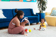 © BONNINSTUDIO/Stocksy - Black mother playing with baby in living room