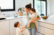 © BONNINSTUDIO/Stocksy - Multitask woman on the phone with kids at home