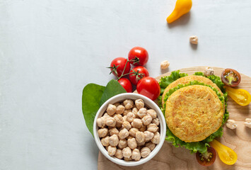 Fresh vegan cutlets, tomatoes, lettuce and bowl with chickpeas on a wooden board. Home made with vegetables and chickpeas.The concept of healthy and vegetarian food.  Plant based food concept