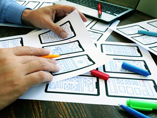 Ux ui designer working with web mobile app sketches.