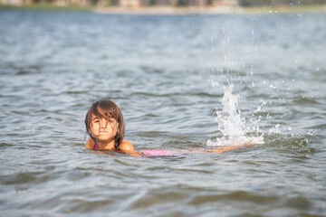 Poster - Young girl learning to swim in a mountain lake