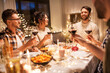 © Syda Productions - holidays, celebration and people concept - happy friends having christmas dinner at home drinking non-alcoholic red wine
