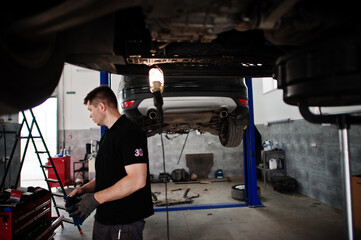 Car repair and maintenance theme. Mechanic in uniform working in auto service.