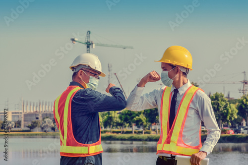 Fotomural Engineers saluting each other by touching elbows,Two business people shake hand