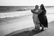 © DisobeyArt - Plus size women dancing on the beach having fun during summer vacation - Curvy female laughing together - Overweight body and happiness concept - Black and white editing