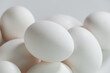 Nahaufnahme mehrerer weißer Eier vor einem hellen Hintergrund