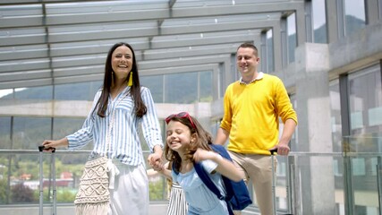 Wall Mural - Family with two children going on holiday, walking at the airport with luggage.