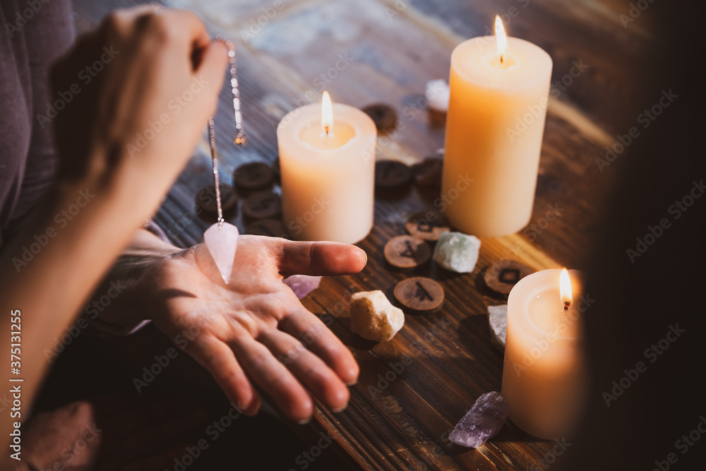 Librate with an pendulum over the hand, healing or oracle foretelling - obrazy, fototapety, plakaty 