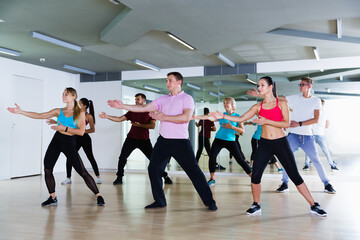 Wall Mural - Happy different ages adults training swing steps at dance class