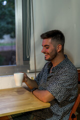 Canvas Print - Shallow focus shot of a young brunette male drinking a hot drink