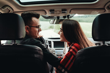 Young Beautiful Couple Sitting in the Car and Enjoying the Roadtrip