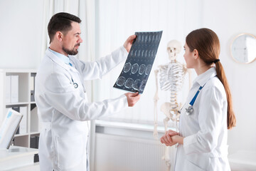 Poster - Professional orthopedist and his colleague examining X-ray picture in office