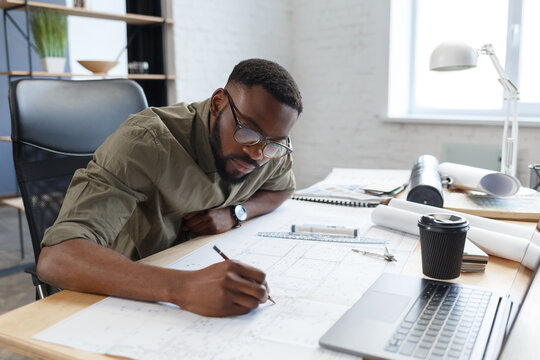 afro-american architect working in office with blueprints.engineer inspect architectural plan, sketc