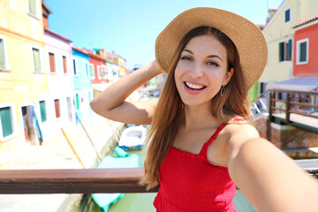 Wall Mural - Young tourist woman taking selfie photo on summer vacation in Burano old town, Venice, Italy