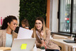 © Zoran Zeremski - Group of a young female businesswoman working in an office while sitting at a table with colleagues.
