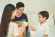 © THESHOTS.CO - Asian thai family cheer and toast with healthy beverage drink.