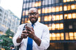 © BullRun - Successful black businessman using smartphone