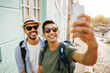 © kleberpicui - Two happy male tourists taking self portrait. Travel and love concept in Latin America