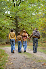 Poster - Family of four walking in autumn forest