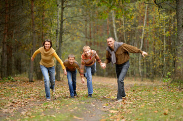 Poster - Family of four having fun in autumn forest