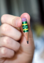 Child Holds A Pencil That Has Been Sharpened To A Nub