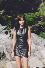 A Beautiful Girl In A Leather Dress By Large Rocks Outside