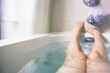 © Holly Clark/Stocksy - A woman's legs and feet in a bathtub.