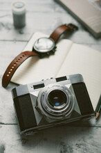 Analog Camera And Man's Wristwatch On The Desk