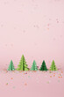 Christmas composition with paper trees with flying confetti. Christmas origami fir trees with copy space for text. New Year's minimal concept.