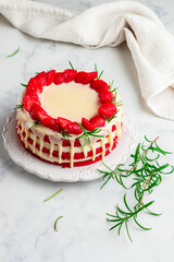 Wall Mural - Homemade red velvet cake with white chocolate,  fresh strawberries and rosemary. Delicious gourmet dessert in a white plate on a marble surface close-up. Selective focus, copy space