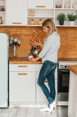 girl in the home kitchen pours coffee into a cup