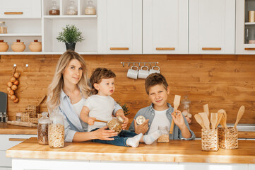 Mom with her 2 years old child cooking holiday pie in the kitchen to Mothers day, casual lifestyle photo series in real life interior