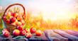 Red Apples In Basket On Aged Table With Defocused Sunset In Background - Fall And Harvest Concept 